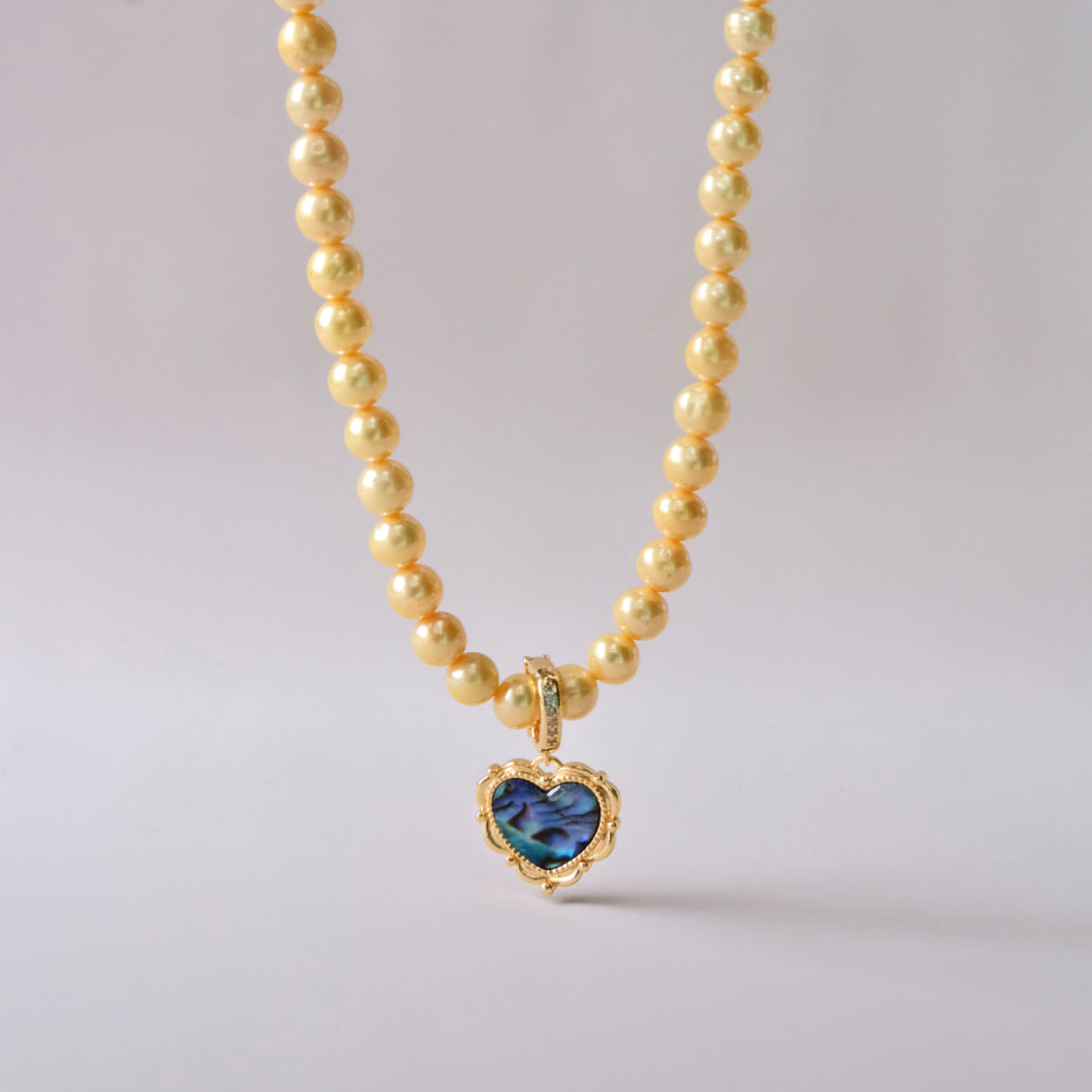 Yellow colored pearls necklace with mother of pearls heart pendant