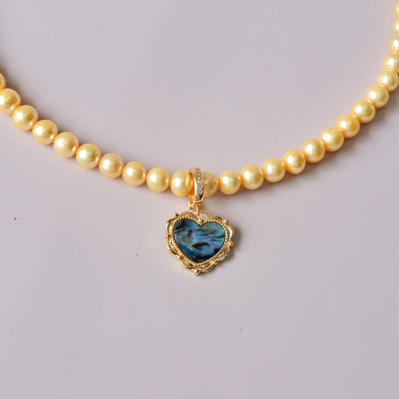 Yellow colored pearls necklace with mother of pearls heart pendant